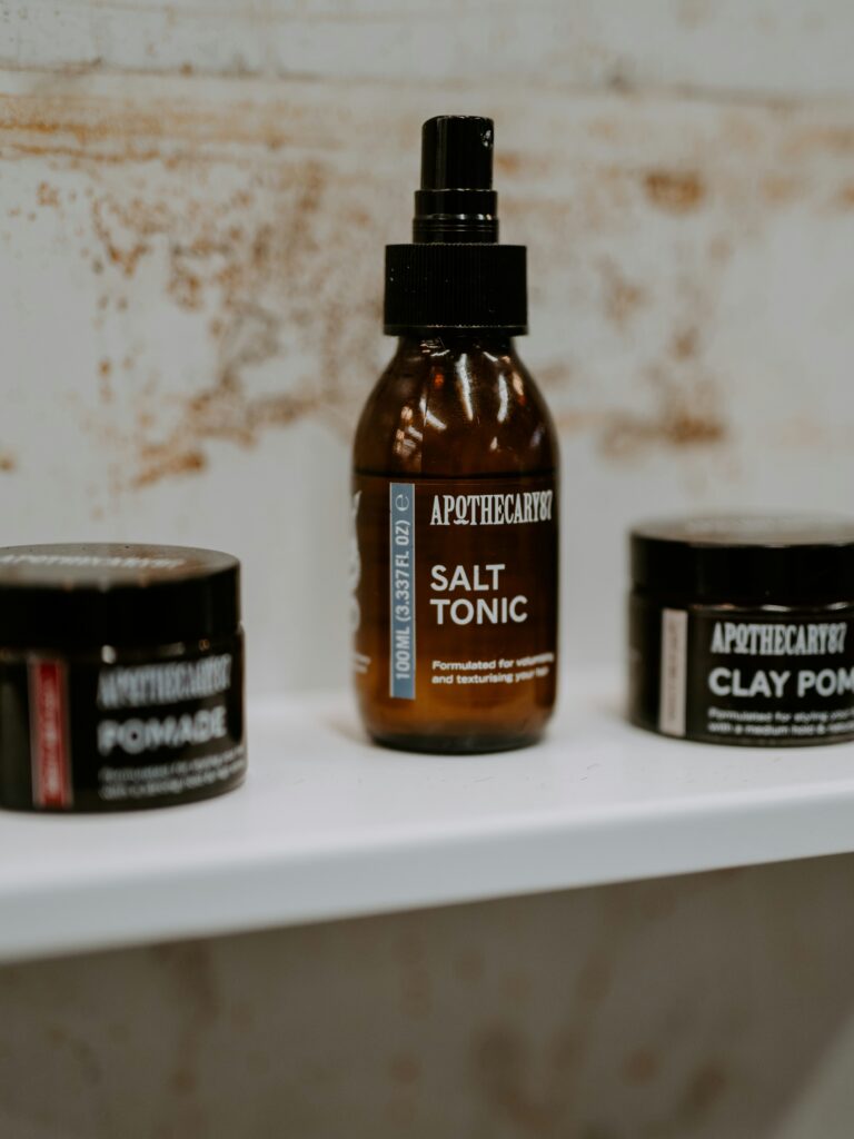 [ALT_TEXT: Una variedad de productos de peinado para cortes mullet en envases marrones sobre una estantería blanca.]