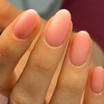 Primer plano de manicura BIAB en tono rosa translcido