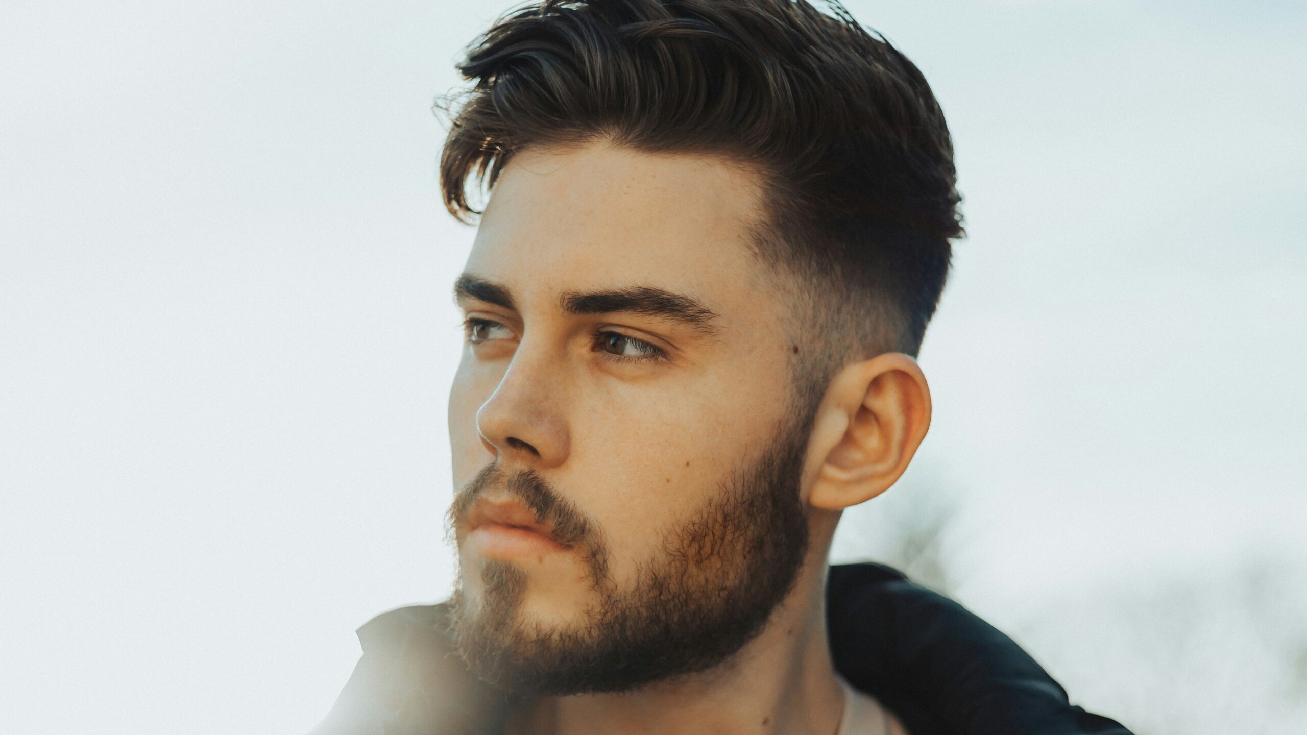 Hombre de pie al aire libre con cabello oscuro y un taper fade con la parte superior texturizada