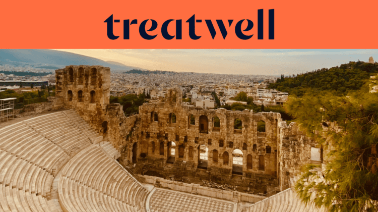 El Odeón de Herodes Ático, un antiguo anfiteatro de piedra al pie de la Acrópolis de Atenas, con el horizonte de la ciudad moderna extendiéndose a lo lejos bajo un cielo dorado al atardecer. Un banner coral con el logotipo de Treatwell aparece sobre la imagen.