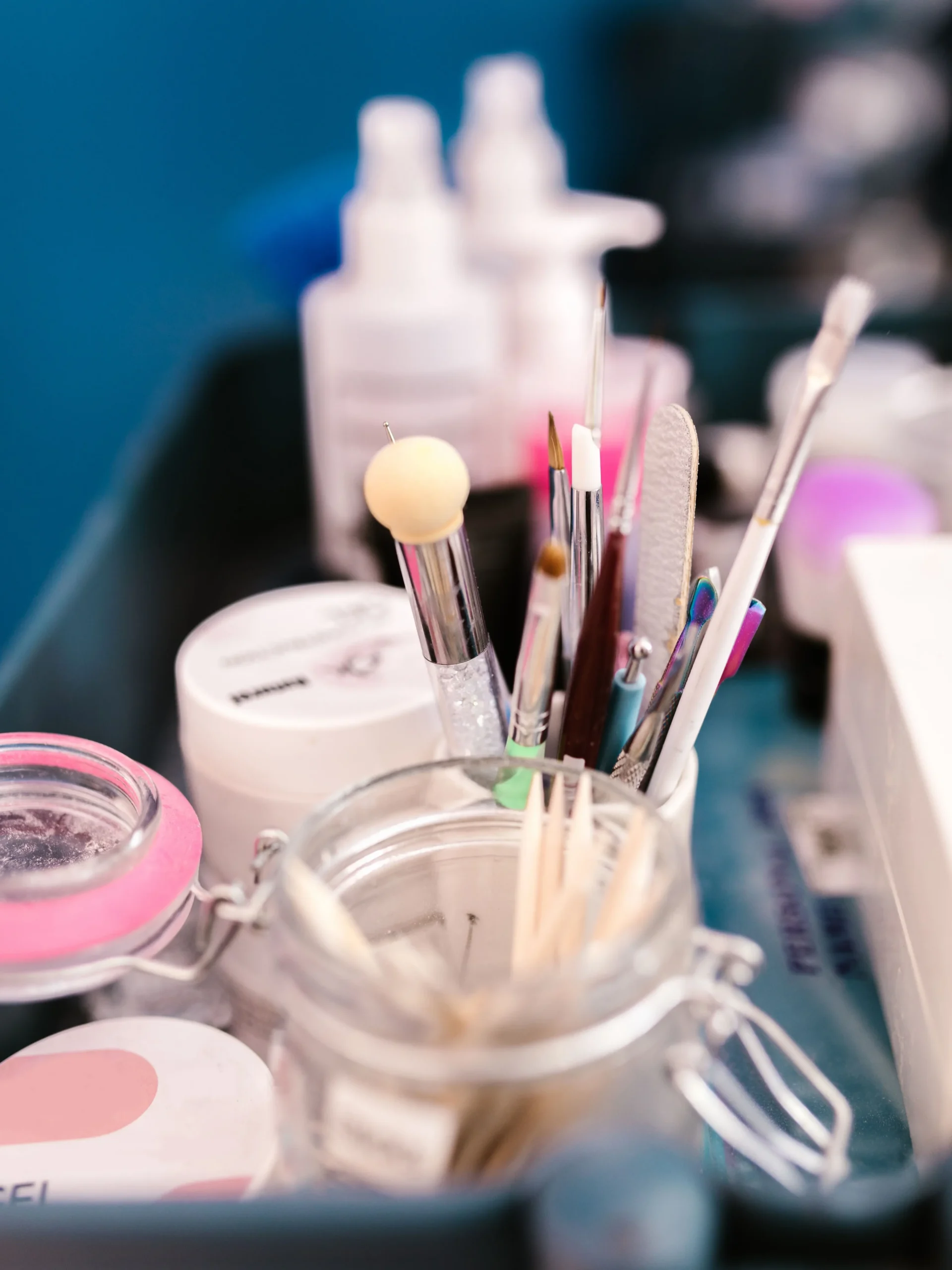 Primer plano del puesto de trabajo de una manicurista en un centro, con herramientas, pinceles y productos de manicura