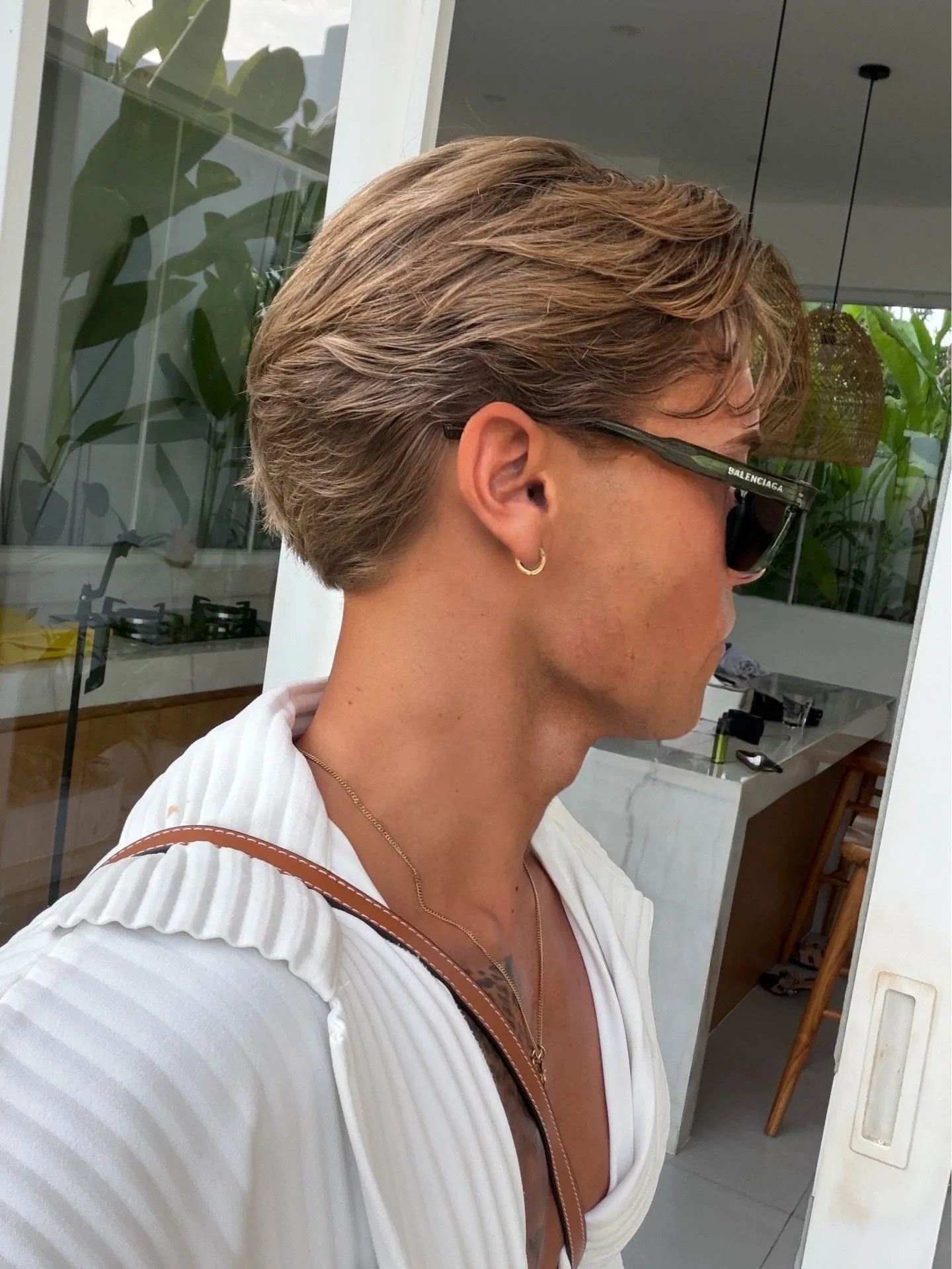 Perfil de un corte masculino flow texturizado, mechones peinados hacia atrás y movimiento natural