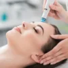 Primer plano de una mujer relajada con los ojos cerrados durante un tratamiento HydraFacial en un centro tranquilo