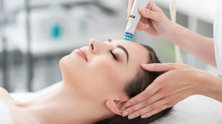Primer plano de una mujer relajada con los ojos cerrados durante un tratamiento HydraFacial en un centro tranquilo