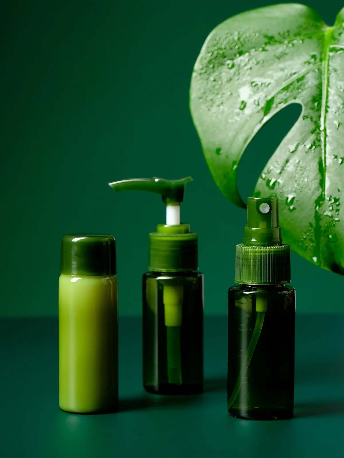 Foto de producto de tres geles y cremas calmantes en frascos verdes, con una gran hoja tropical verde de fondo