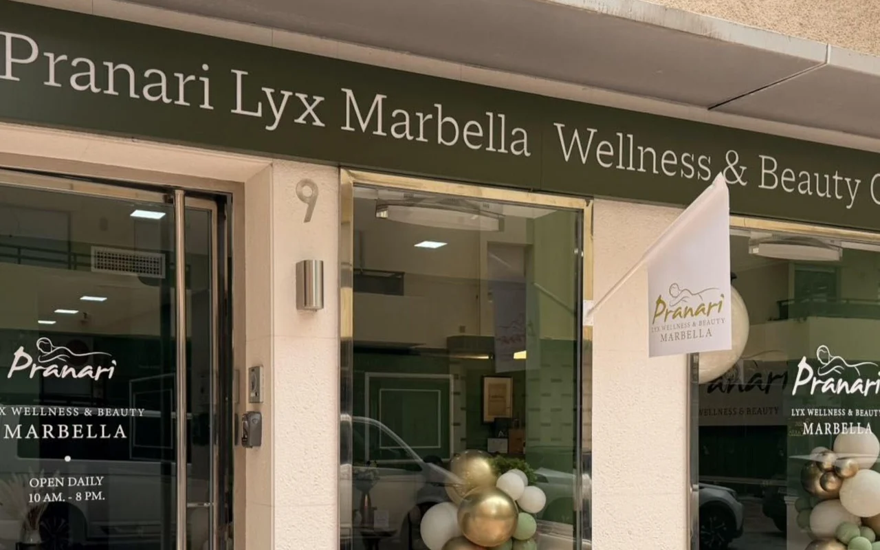 El local de Anchan Massage en Marbella, un estudio de bienestar y belleza de fachada verde con globos blancos y dorados junto a la entrada de cristal.