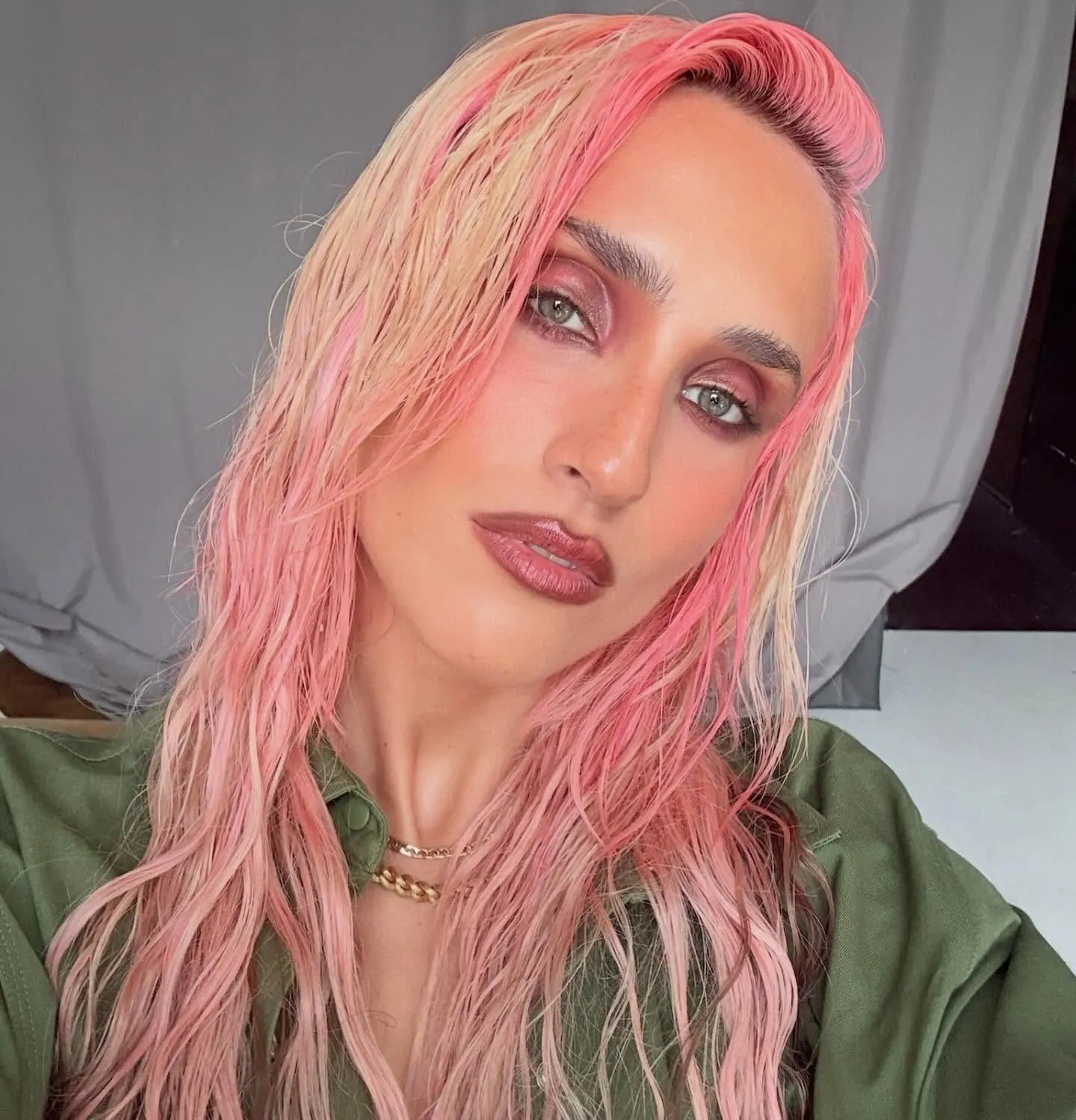Melena larga y ondulada en rosa con reflejos melocotón y rubios, peinado con efecto mojado y textura, retrato veraniego de estilo editorial